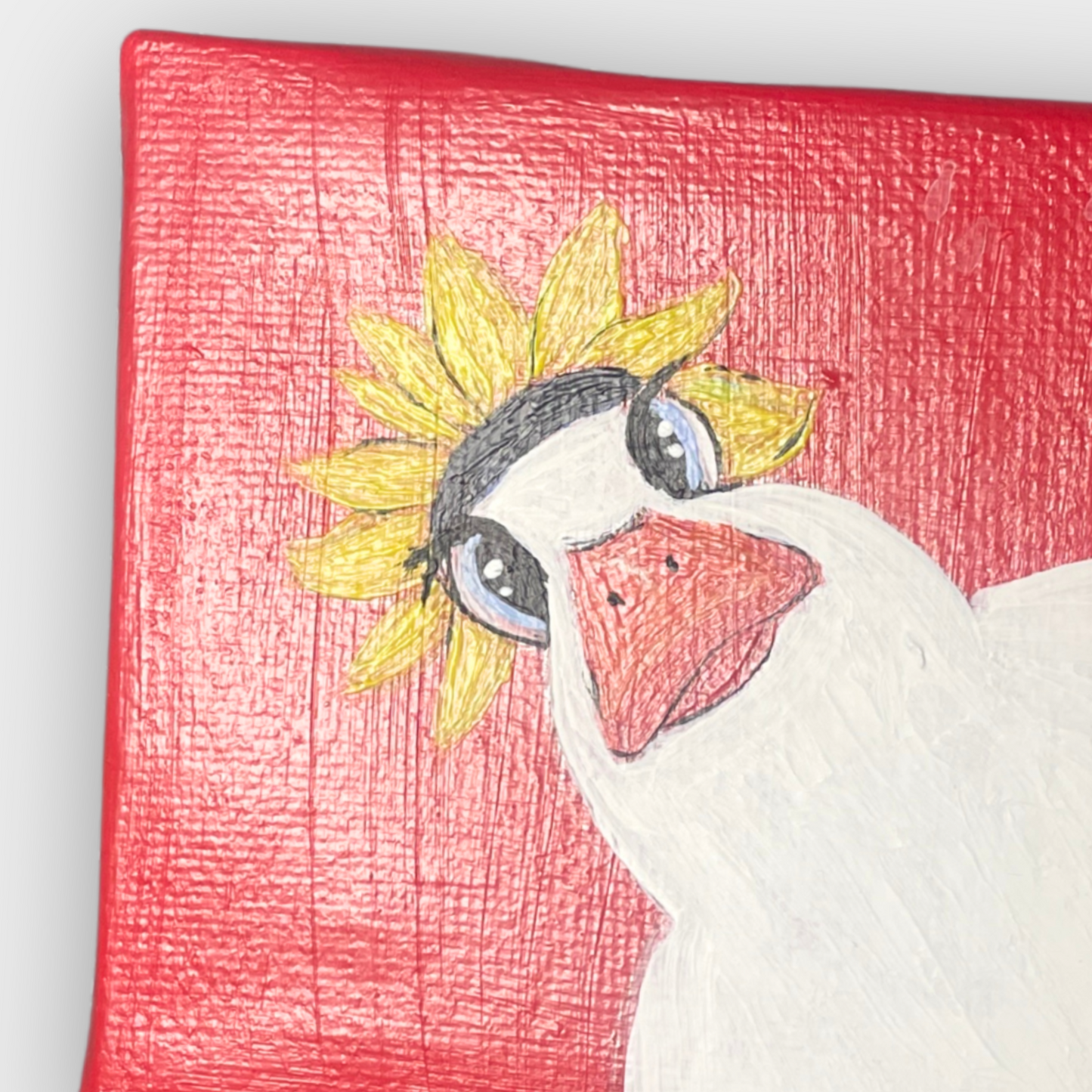 Detailaufnahme der handgemalten Ente mit Sonnenblume als Hut auf rotem Hintergrund – Mini Leinwand mit Acrylstruktur und verspieltem Ausdruck.