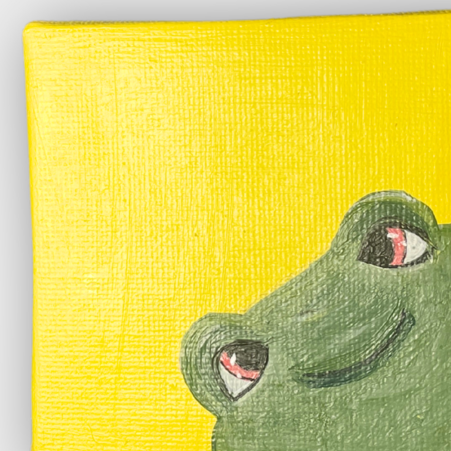 Detailansicht der Acrylmalerei auf Mini Leinwand: grinsender Frosch mit großen Augen auf leuchtend gelbem Hintergrund – 7x7 cm.