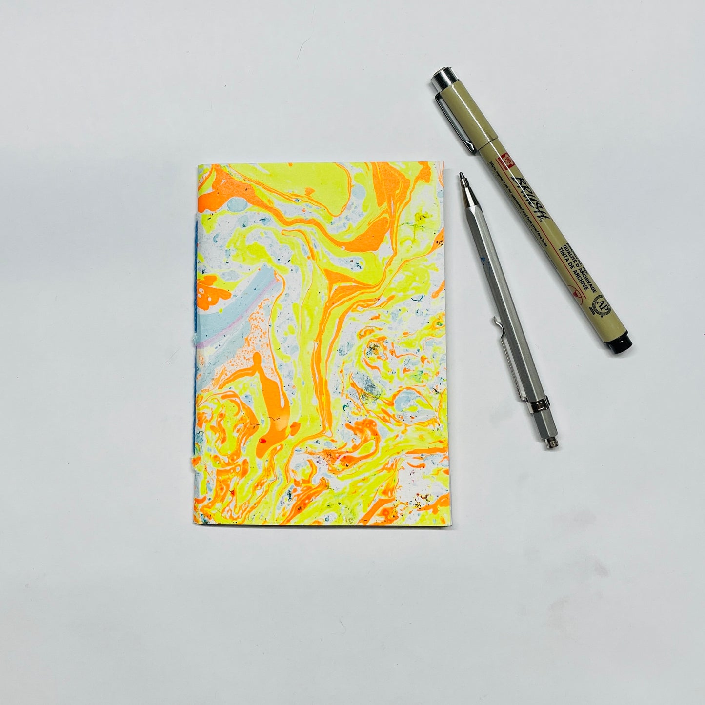 Handgebundenes Notizbuch in A6 mit marmoriertem Cover in gelb,orange