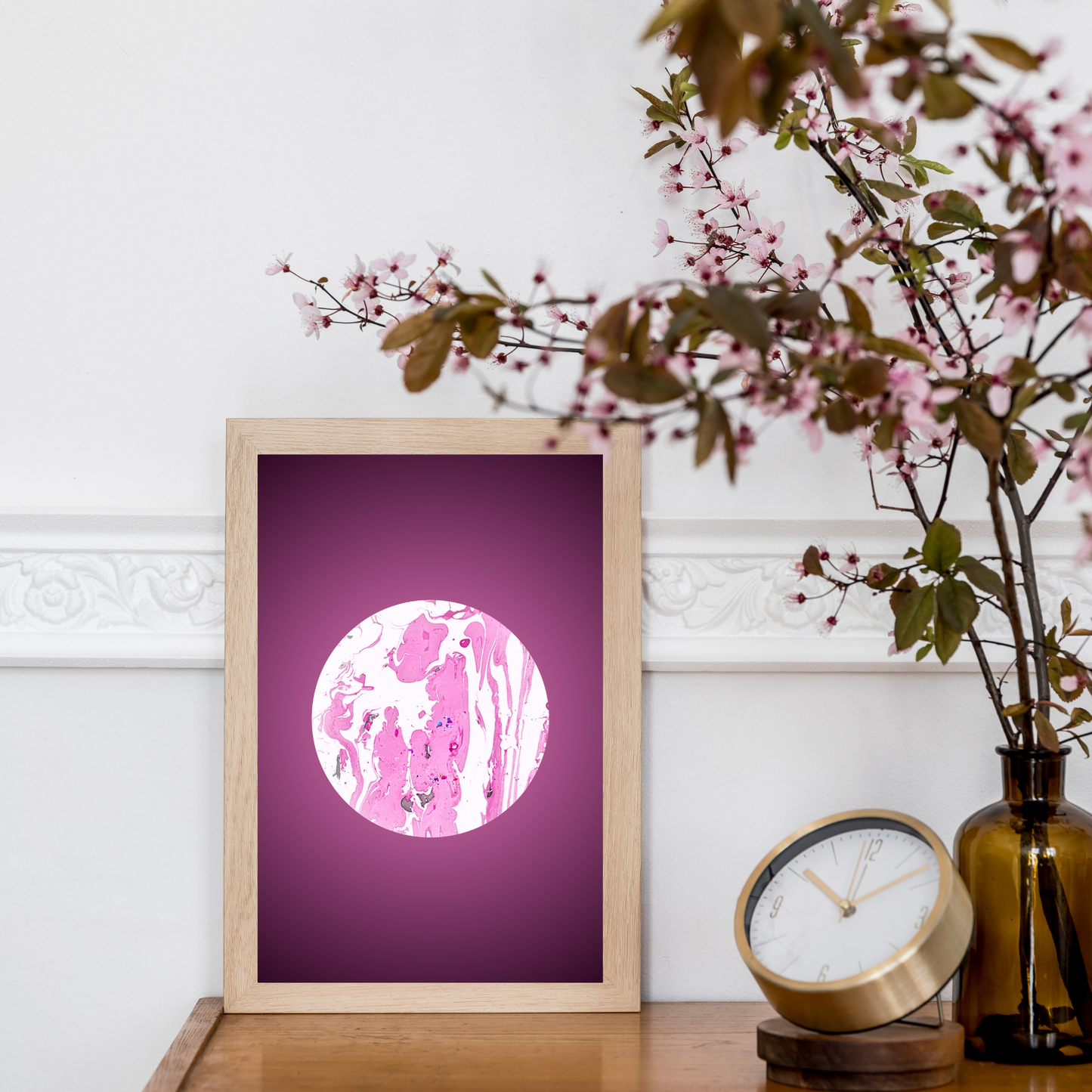 Kunstposter mit marmoriertem Kreismotiv, neben floraler Deko