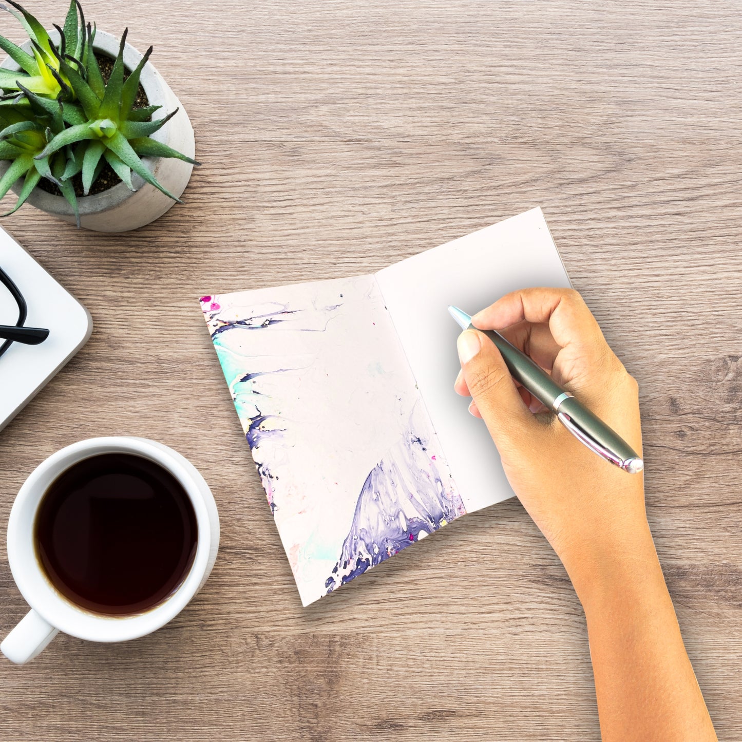 Journaling-Moment mit dem Ysra Notizbuch, einer Tasse Kaffee und Pflanzen.