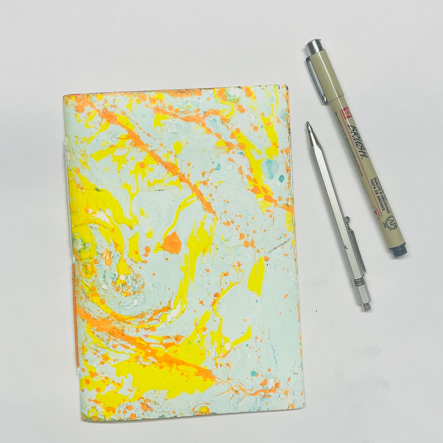 Handgebundenes Notizbuch mit Marmorpapier in gelb, orange, blau