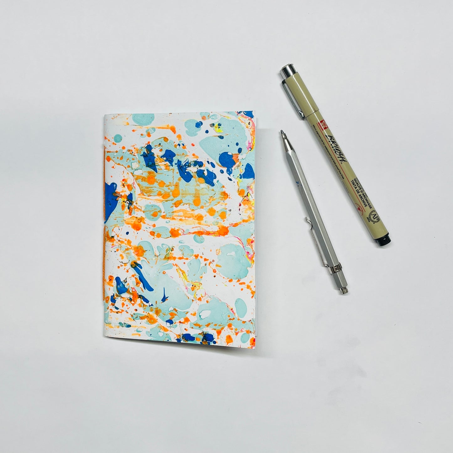 Handgebundenes Notizbuch in A6 mit marmoriertem Cover in orange,blau