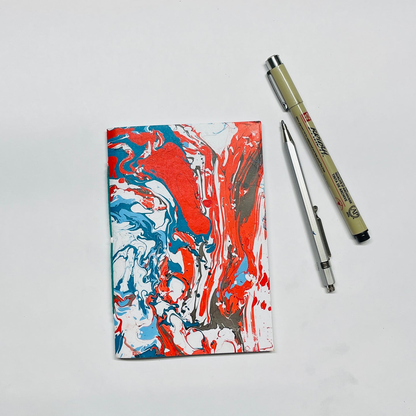 Handgebundenes Notizbuch in A6 mit marmoriertem Cover in rot,blau,schwarz – kreative Papeterie für Planung & Alltag