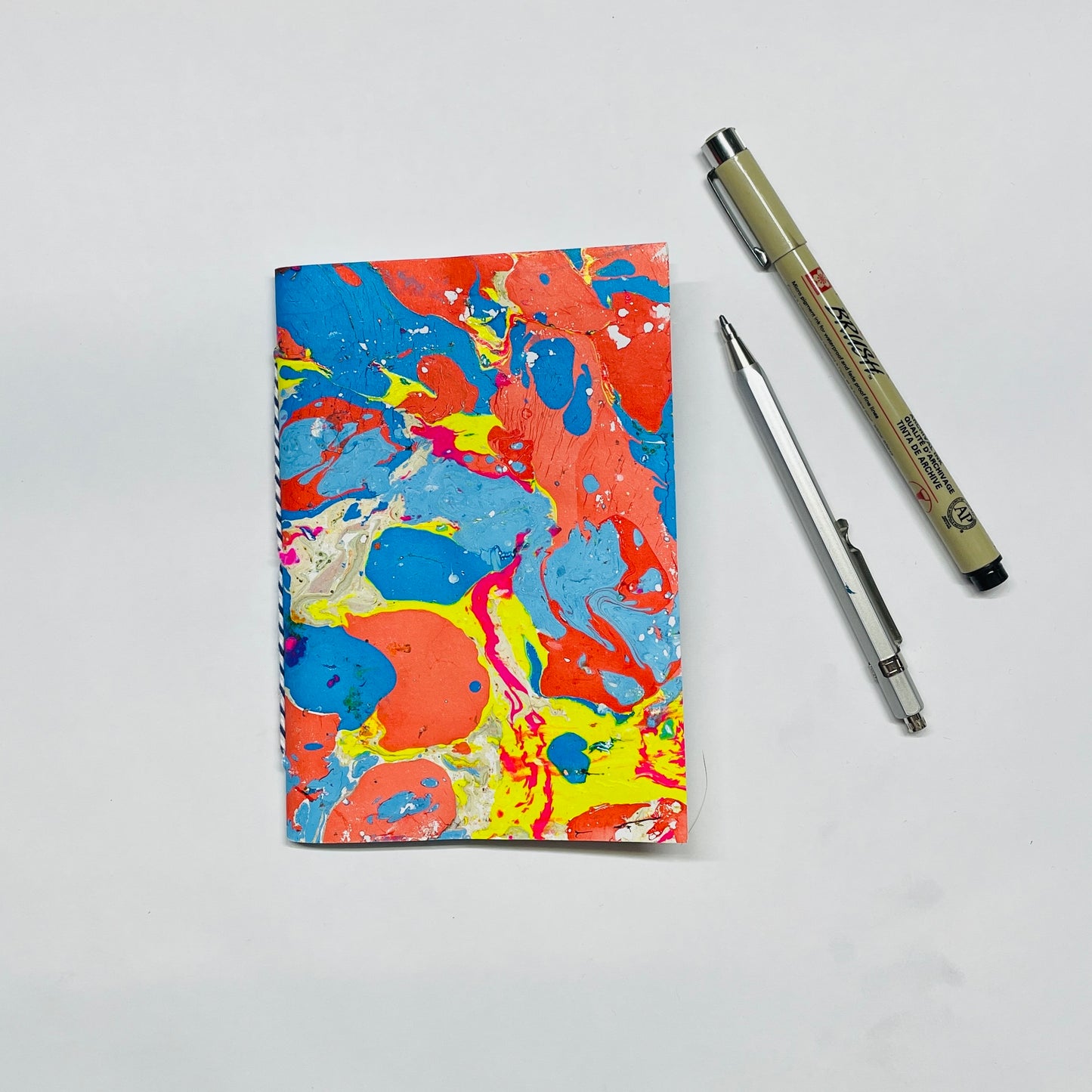 Handgebundenes Notizbuch in A6 mit marmoriertem Cover in rot,blau,gelb– kreative Papeterie für Planung & Alltag