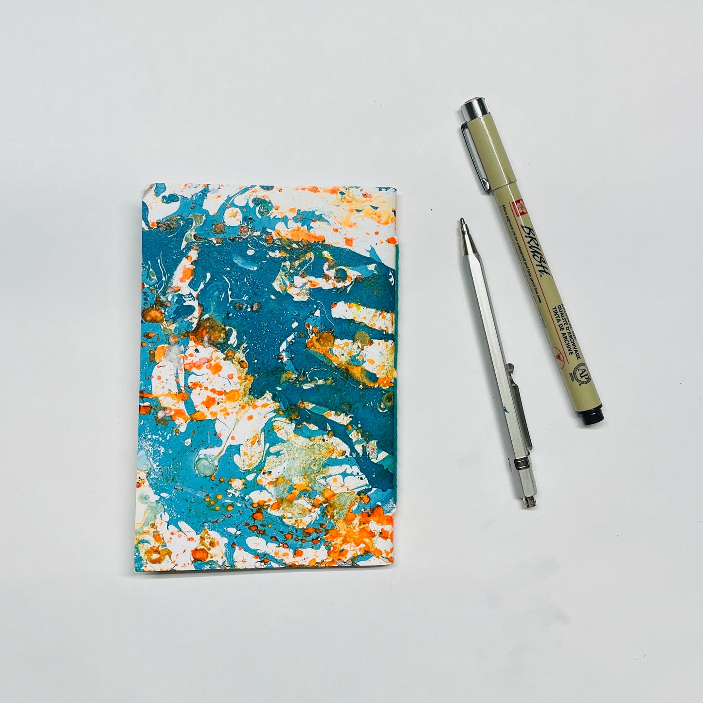 Handgebundenes Notizbuch in A6 mit marmoriertem Cover in blau,orange– kreative Papeterie für Planung & Alltag