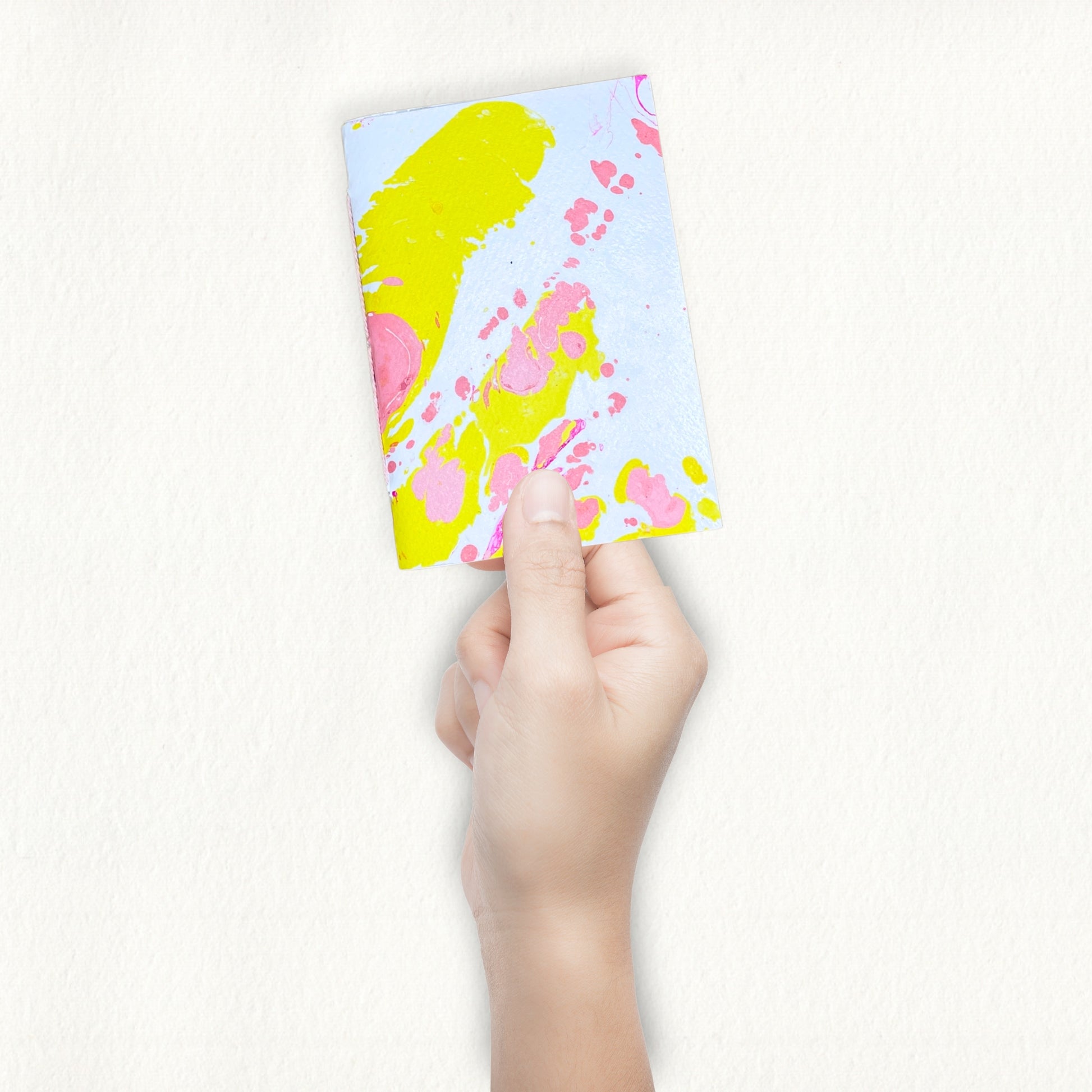 Handmade Notizbuch wird in der Hand gehalten vor weißem Hintergrund 