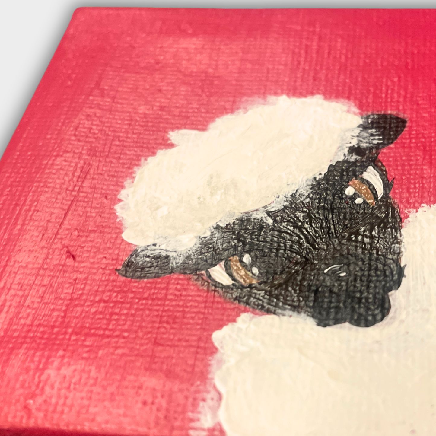 Detailaufnahme des handgemalten Schafes mit lockigem Fell und dunklem Gesicht auf rotem Hintergrund – Mini Leinwand mit sichtbarer Acrylstruktur.