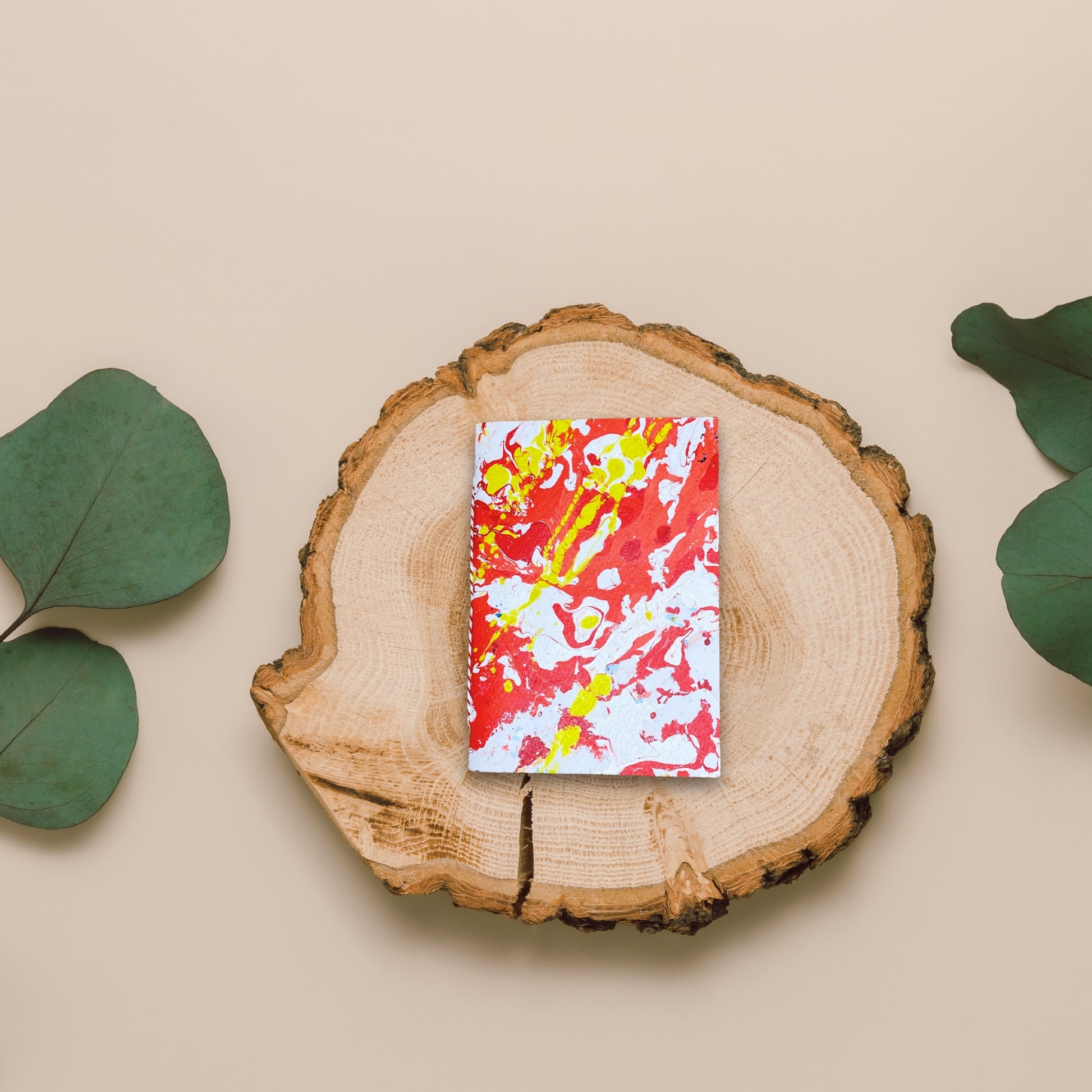 Kreatives Flatlay: Oris liegt auf einem Holzbrett mit grünen Eukalyptusblättern.
