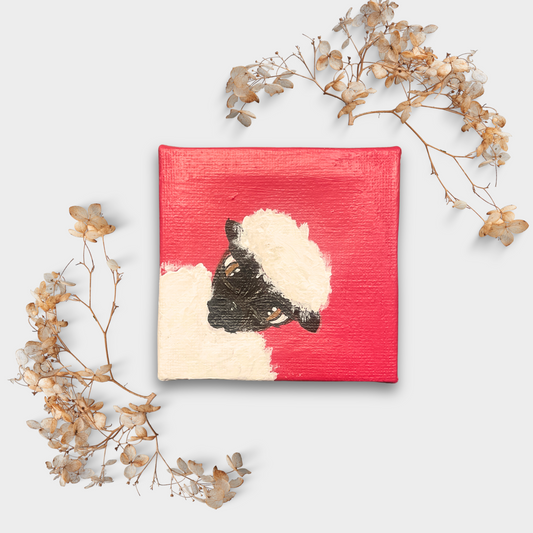 Mini Leinwand mit Schaf auf kräftigem Rot, eingerahmt von filigranen Trockenblumen – liebevoll inszenierte Tierkunst im Kleinformat.