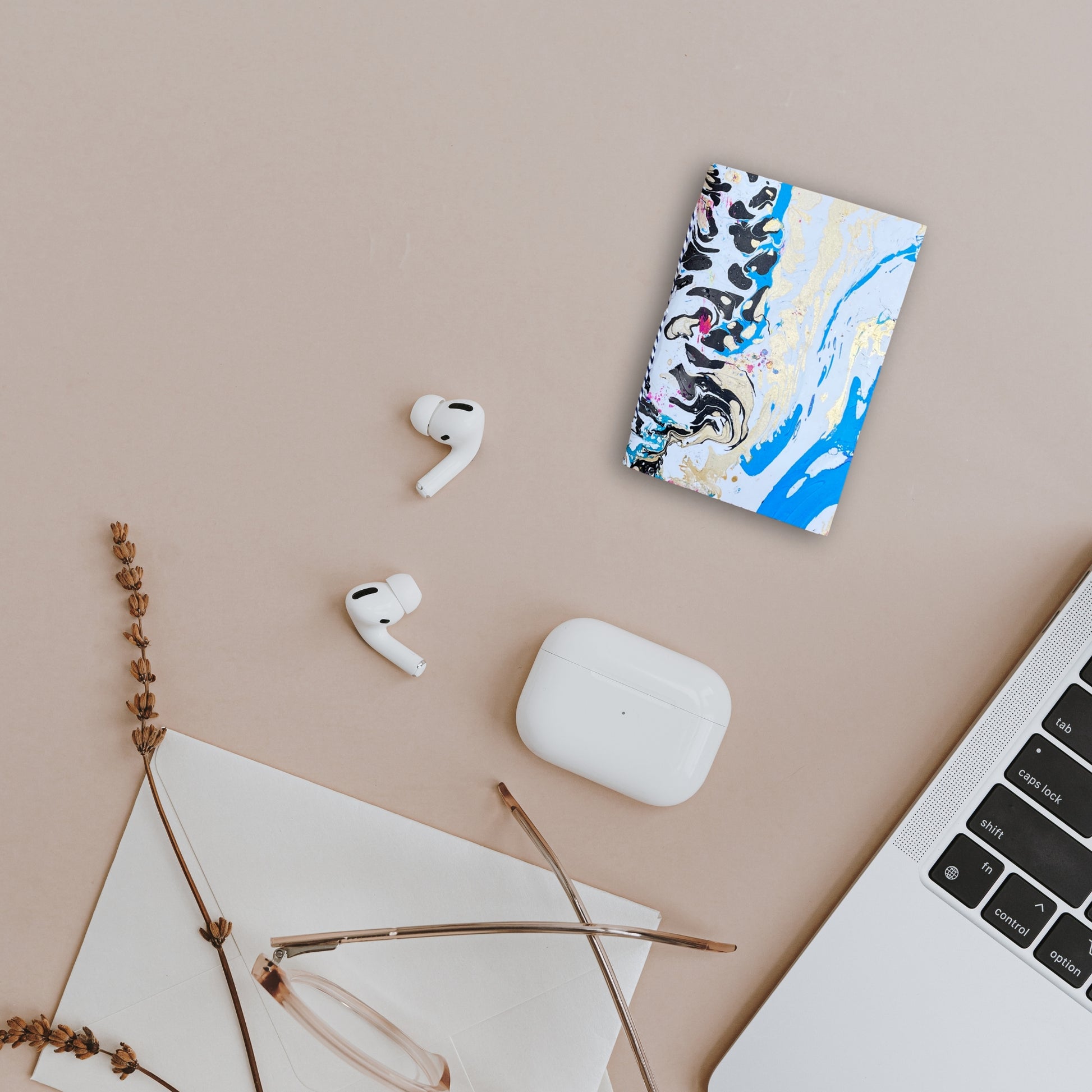 Arlen– einzigartiges Notizbuch auf Schreibtisch neben AirPods und Laptop arrangiert.